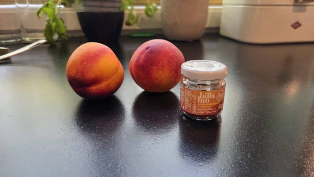 Whole Nectarine and vanilla powder on kitchen counter for kombucha second fermentation recipe